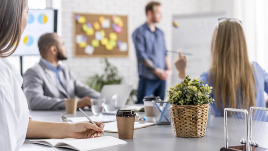 un professeur qui donne un cours en entreprise à plusieurs salariés