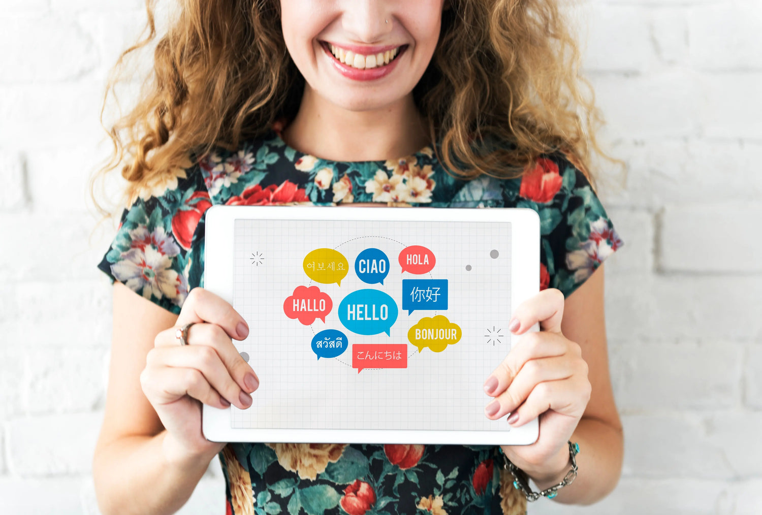 femme qui porte une pancarte avec bonjour écrit en plusieurs langues